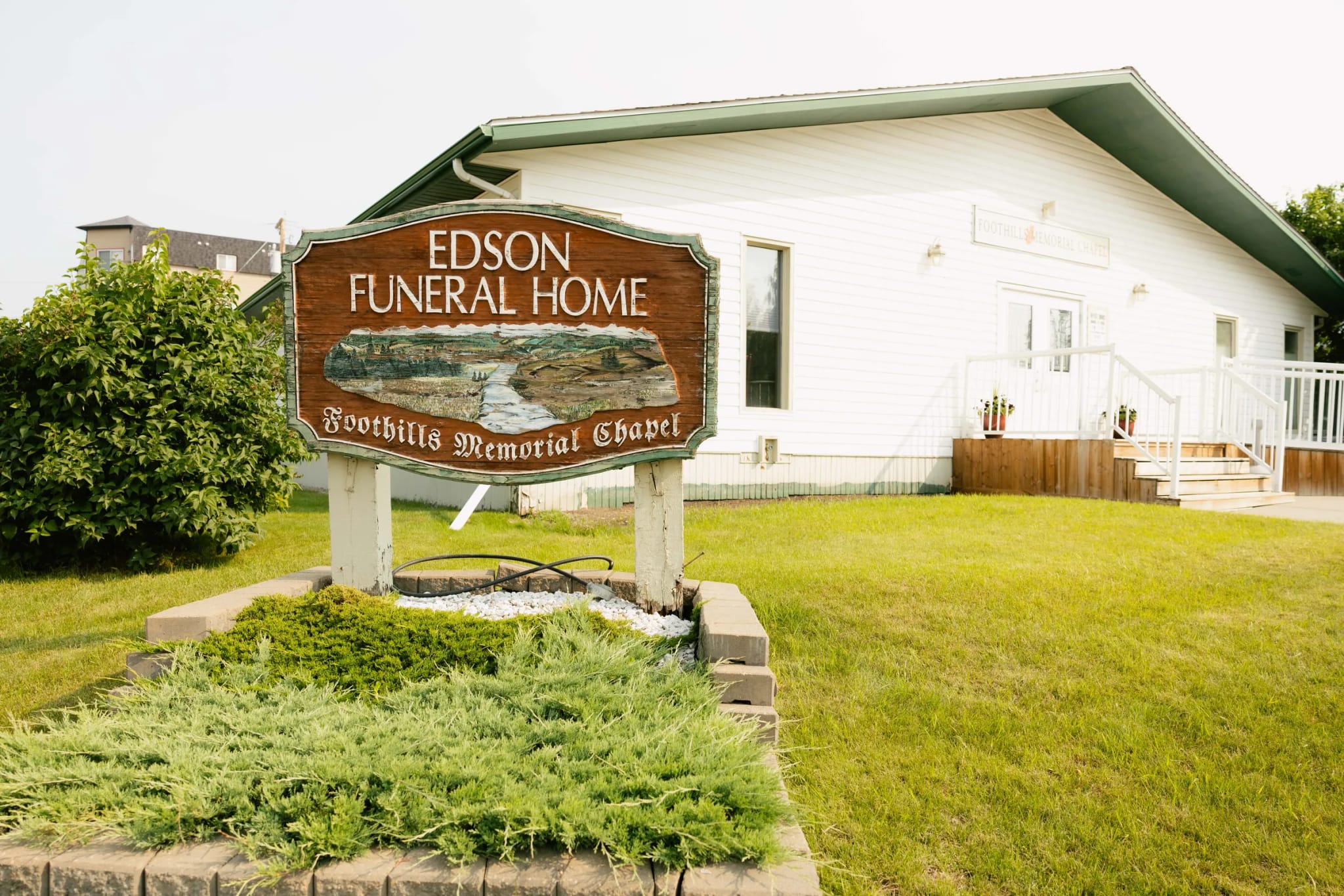 The carved Edson Funeral Home and Foothills Memorial Chapel sign in front of the funeral home on 6 Avenue in Edson, Alberta